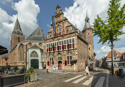 Voorgevel van het Stadsmuseum Woerden in het historische Oude Raadhuis met rode luiken en bezoekers op het plein, Groene Hart.