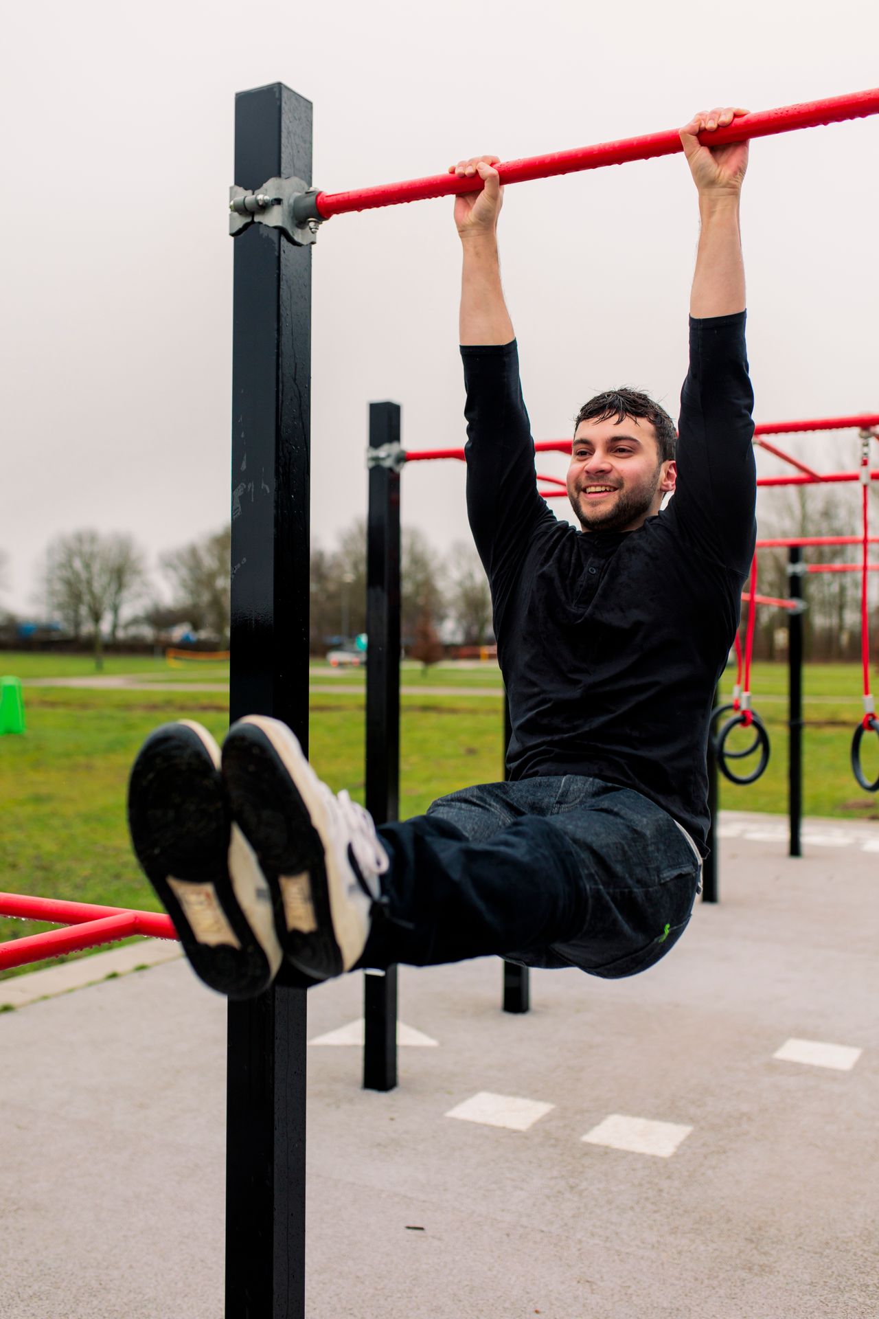 Man hangend aan een stang in een urban sportspark
