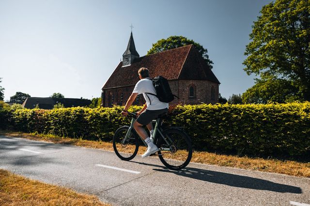 Ein Mann fährt im Sommer mit dem Fahrrad durch Drenthe.