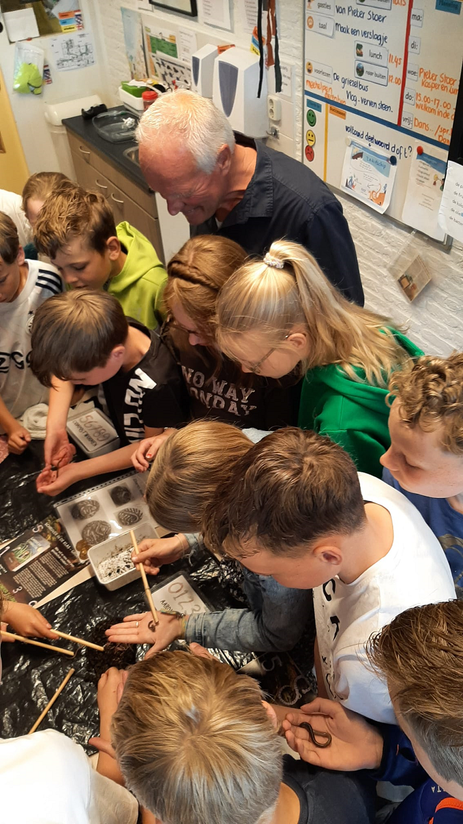 Kinderboekenschrijver Pieter Stoer met een groep kinderen aan de slag.