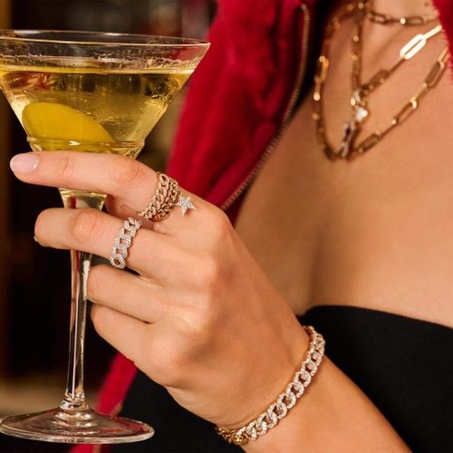 Een dame met champagne en diverse sieraden.