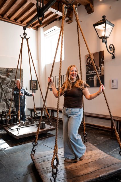 Historisch museum Heksenwaag Oudewater, Groene Hart, bezoekers op de originele waag in monumentaal interieur met eeuwenoude balans, gewichten en historische tentoonstelling over de heksenwaag.
