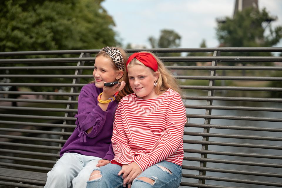 Twee kinderen luisteren een audiofragment bij Molenmuseum De Valk, één van de stops van de familie audiotour Stad van Ontdekkingen