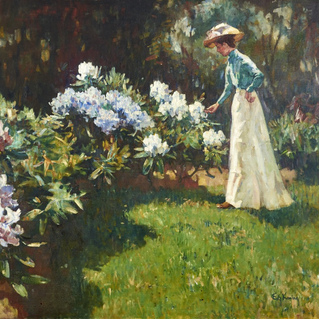 Vrouw met hoed in tuin met bloeiende rododendrons