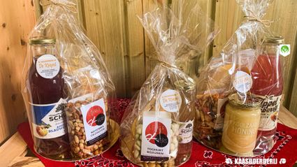 Landwinkel Kaasboerderij De Koepel, Harmelen, provincie Utrecht, Groene Hart, houten schap met streekproducten en geschenkverpakkingen met boerenkaas, appel-perensap, notenmix, yoghurtrozijnen en koolzaadhoning.