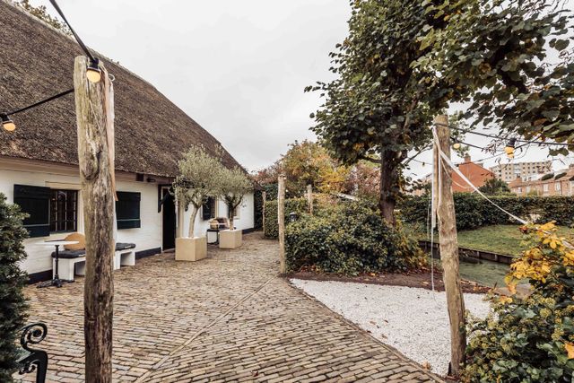 Evenementen- en vergaderlocatie De Willemshoeve in Woerden, Groene Hart. Authentieke boerderijlocatie met rieten dak, sfeervolle binnenplaats, bestrating, bomen en buitenruimte voor vergaderingen, bruiloften en zakelijke bijeenkomsten.