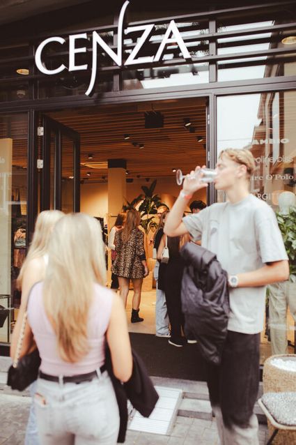 Kledingwinkel Cenza in Woerden, provincie Utrecht, Groene Hart, bezoekers met wijnglazen voor de winkel tijdens het evenement Woerden Proeft Wijn.