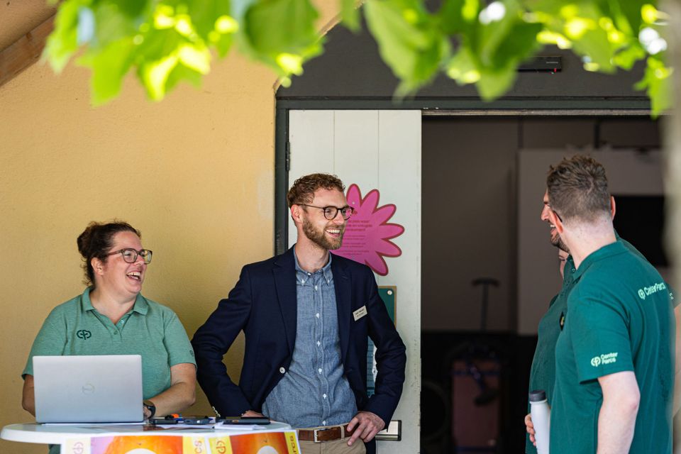Joost staat samen met collega's achter een balie bij Centerparcs Port Zelande