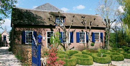 Boerderij De Blauwe Deel met een goed bijgehouden tuin voor de deur.