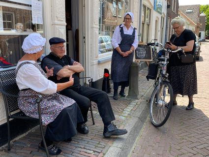 Mensen in oude klederdracht voor de Ballensnoeperij