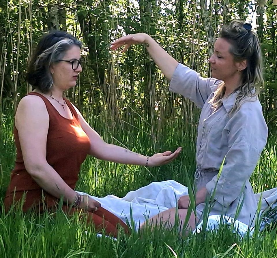 Vrouw die reiki uitoefent buiten in het bos