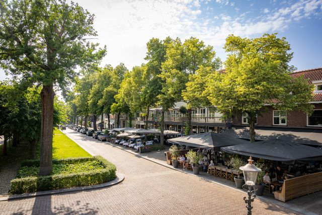 Overzicht van een aantal terrassen vol mensen op De Lind in Oisterwijk en het groene Trouwlaantje