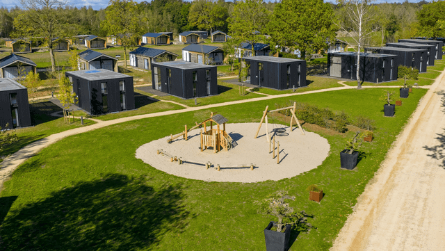 Overzichtsfoto van boven met vakantielodges in groene omgeving