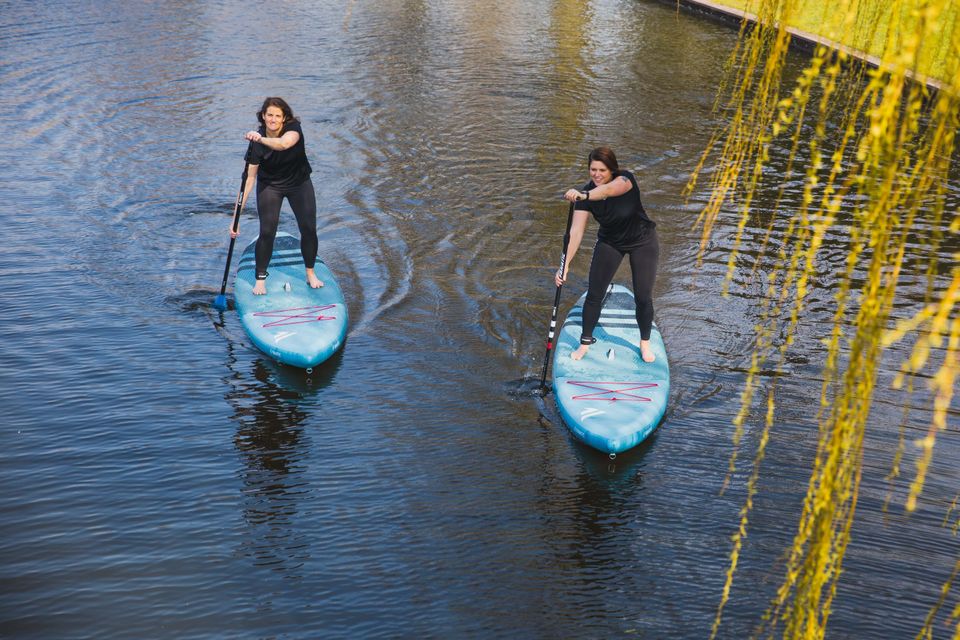 Twee vrouwen suppen over het water in Woerden tijdens een sportieve activiteit van Sportsaeck