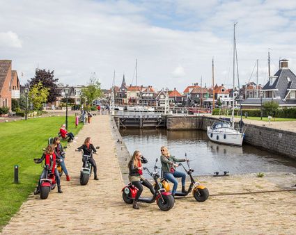 Een groepje vrouwen zitten op hun e-chopper bij de sluis in Lemmer.