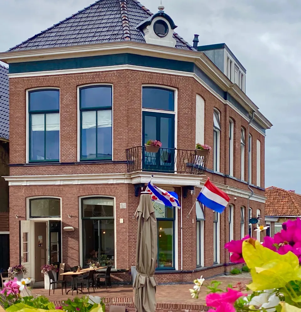 De gevel van Boutique Hotel Joure in Joure met de Nederlandse en Friese vlag uit.