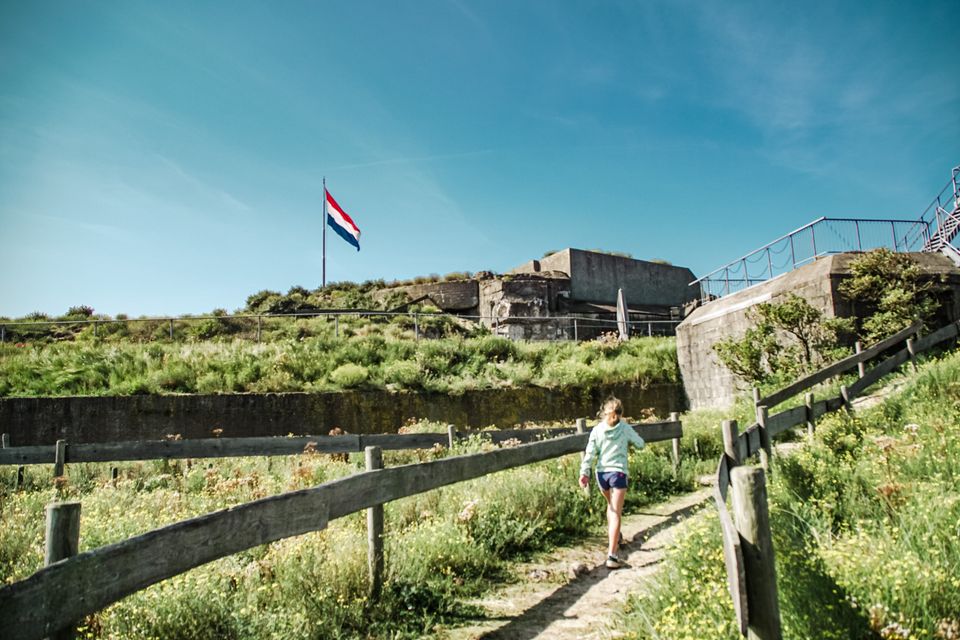 Kinderen spelen op een forteiland omgeven door veel beton.