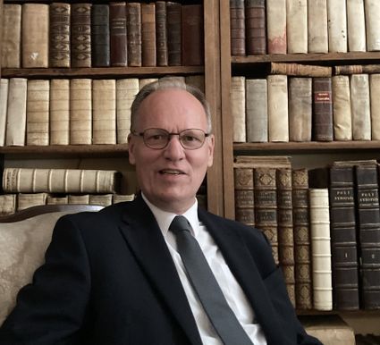 Taxatiemiddag oude boeken met Arie Molendijk in Kasteel Woerden, Groene Hart, boekentaxateur zittend voor een kast met historische boeken.