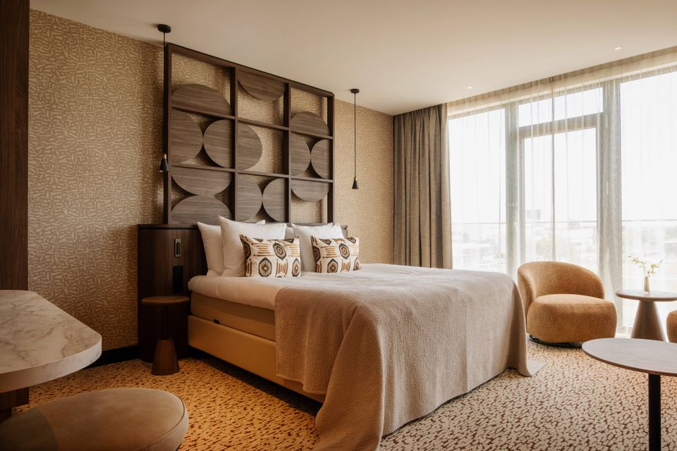Hotel Van der Valk Woerden, Woerden, Groene Hart, stijlvolle hotelkamer met comfortabel tweepersoonsbed, moderne inrichting, zithoek en grote ramen voor een luxe hotelovernachting.