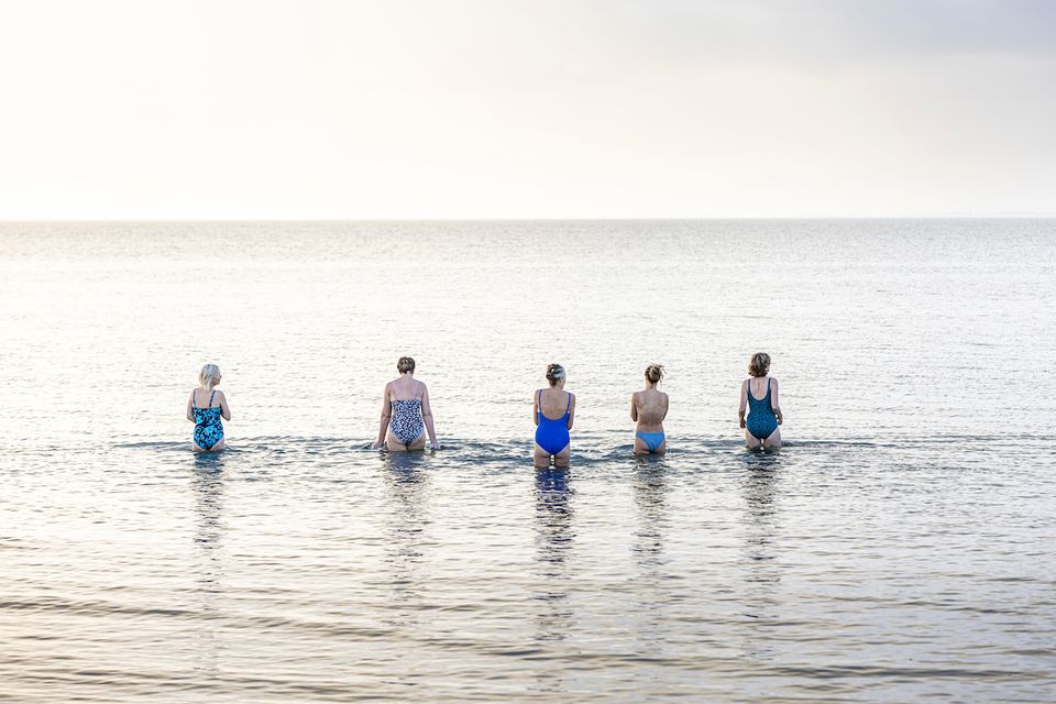 een groep vrouwen lopen het water in