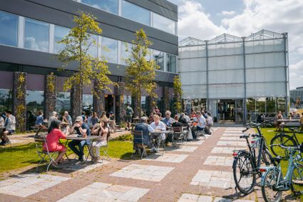 Picnic tables with people in front of one of the BioPartner buildings.