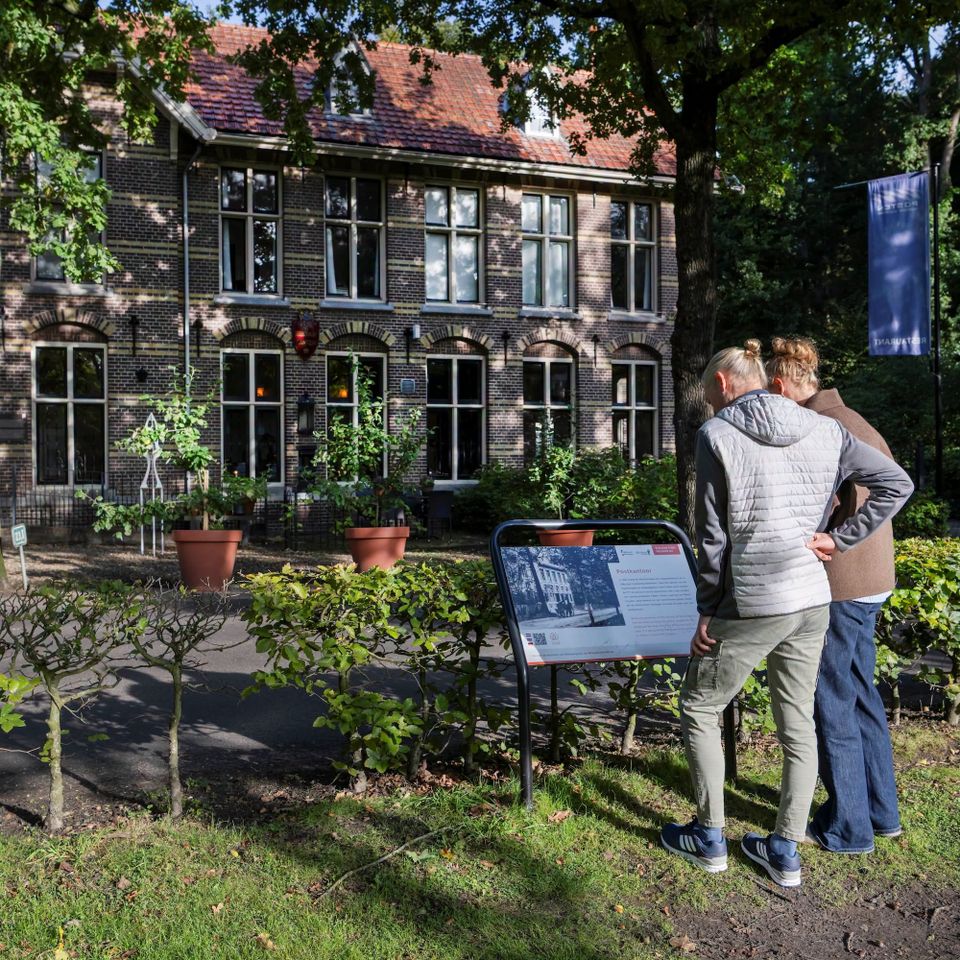 Man en vrouw die het informatiebord bekijken voor Restaurant Posten in Frederiksoord