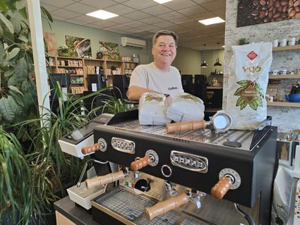 Speciaalzaak WP Koffie en Thee in Woerden, Groene Hart, medewerker achter professionele espressomachine met koffiezakken en koffieaccessoires in een winkel voor koffie, espresso en thee.