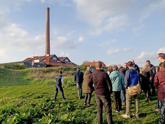 Passagiers hebben het schip verlaten en gaan met de gids op wandelexcursie door de Polder