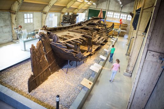 Mensen bezoeken Batavialand en bekijken een scheepswrak in Lelystad, Flevoland