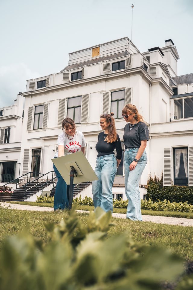 Drie vriendinnen lezen het informatiebord voor Paleis Soestdijk