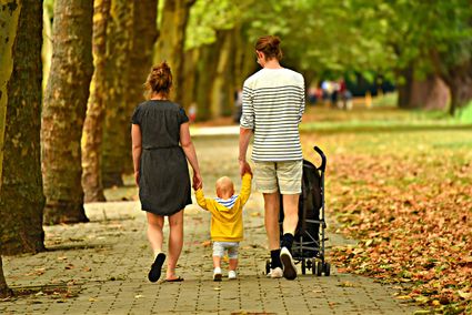 Vader en moeder met kindje aan het wandelen