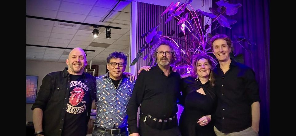 Leden van de Goverts Bluesband omarmen elkaar op het podium