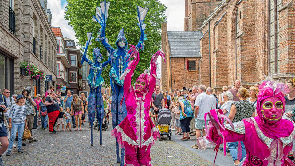Straattheater Festival in Woerden, Groene Hart, kleurrijke performers op stelten en publiek tijdens levendig evenement in historische binnenstad.