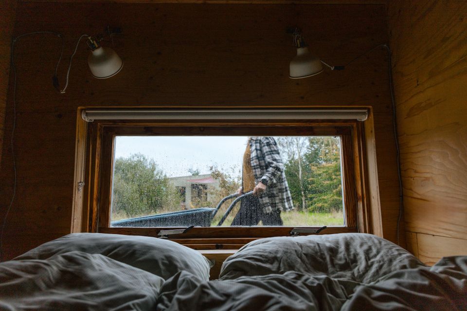uitzicht vanuit bed op gast met kruiwagen in een tiny house