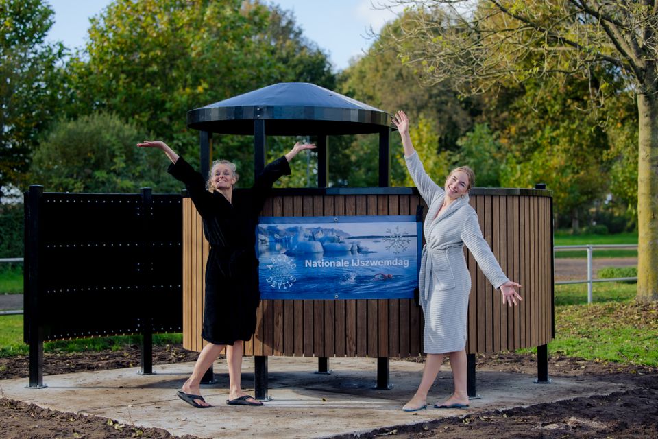 Twee vrouwen staan voor een omkleedhokje.