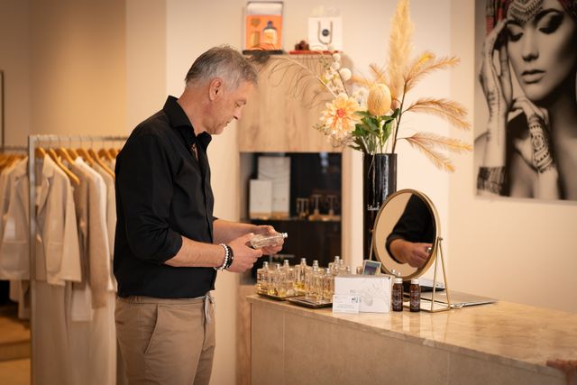 Een man die bij de parfums staat van Hermée