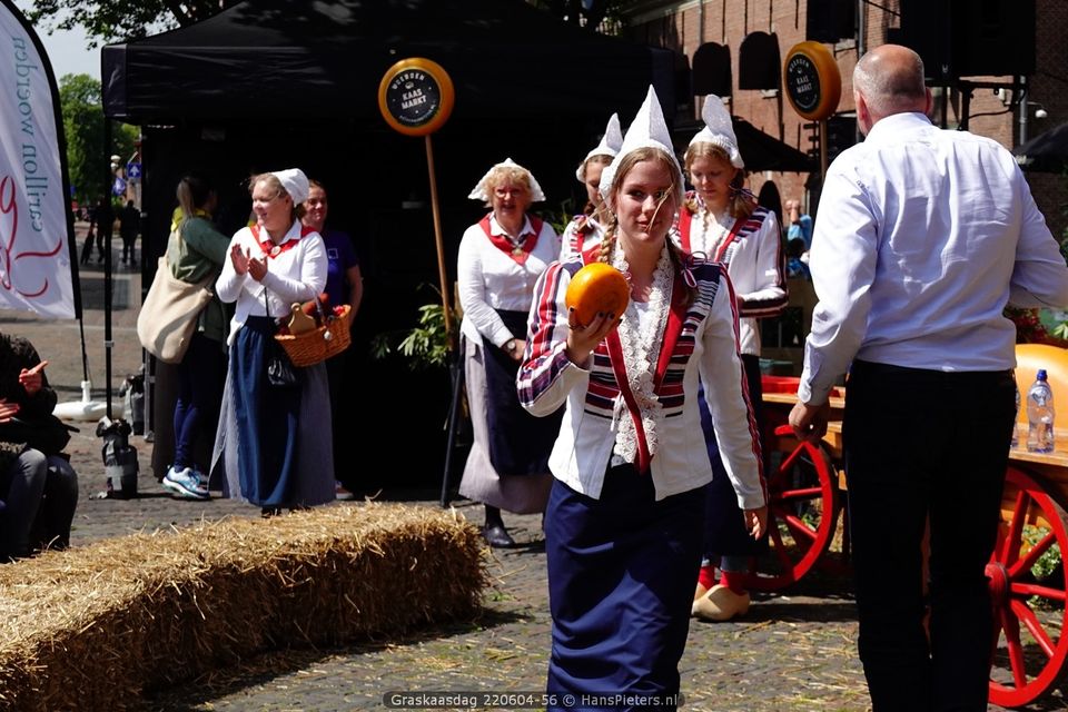 Kaasmeisje in traditionele kleding op de kaasmarkt in Woerden – een vrolijk en fotogeniek boegbeeld van Hollandse kaastraditie.