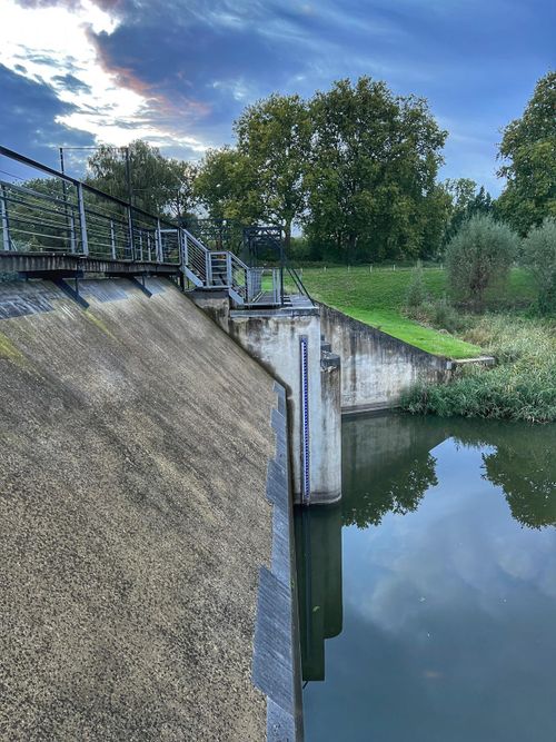 Een groene omgeving met een sluis.