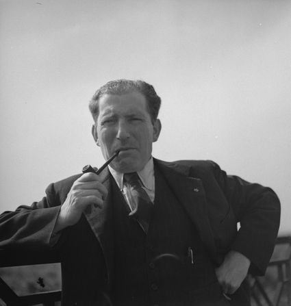 Portret van schrijver Herman de Man uit de Lopikerwaard, Groene Hart, zwart-witfoto waarop hij in driedelig pak met stropdas een pijp rookt.