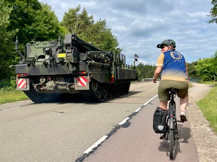 Imke fietst langs militair voertuig op Vliegbasis Soesterberg