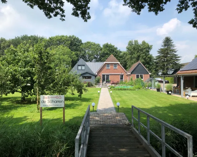 Vooraanzicht van B&B De Scharren in Scharsterbrug op een zonnige dag.