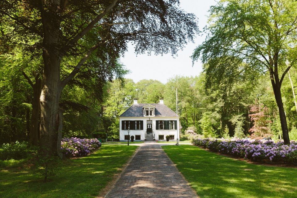 Huis Westerbeek in Frederiksoord omringd door bomen, gezien van een afstand.
