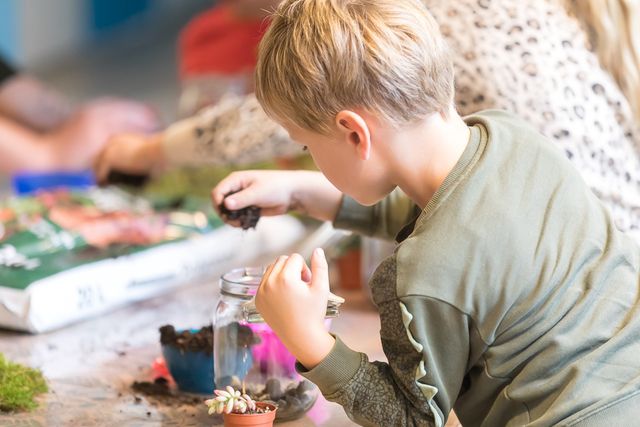 Een jongentje knutselt tijdens de Kindermaand