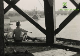 Twee kinderen kijken in 1960 naar de toekomstige Zaanse Schans vanaf de in aanbouw zijnde verfmolen De Kat.