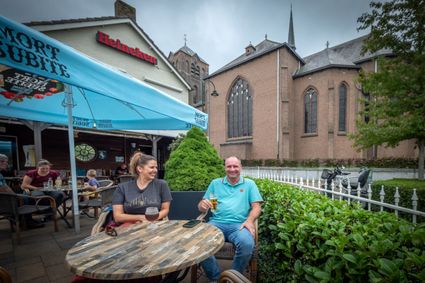 Man en vrouw op het terras van Café Kerkzicht met de kerk op de achtergrond