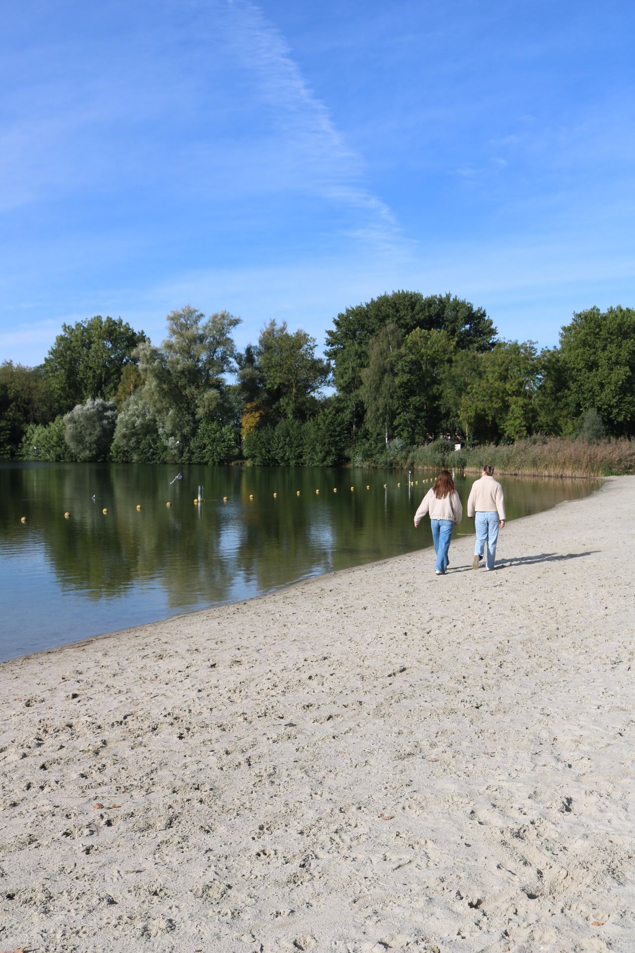 twee vrouwen lopend op het strand in de winter