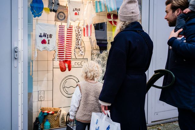 Gezin staat de kijken naar de etalage "Dependance van Sinterklaas" op de Gijsbrecht