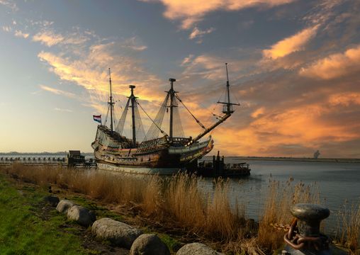 Boot ligt aan kade bij zonsondergang.