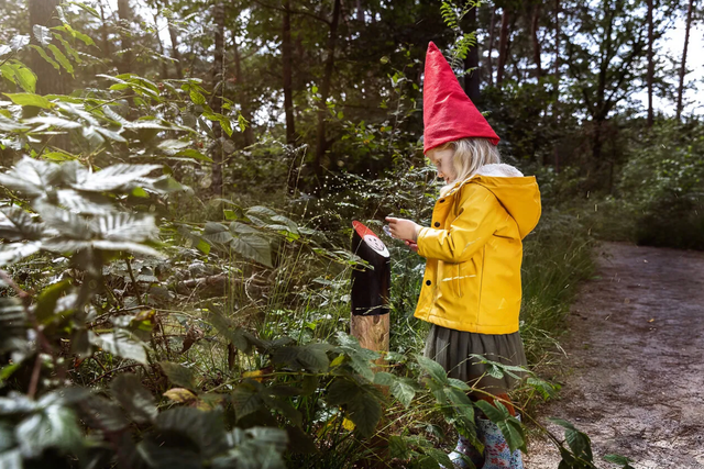 Meisje aandachtig aan het lezen in het kabouterbos.
