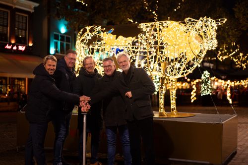 Verschillende mannen die op een knop drukken om de verlichte koe aan te doen
